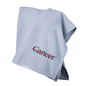 Gray sweatshirt blanket with the black cancer strikethrough logo on the bottom corner.