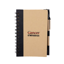 Hardcover black spiral notebook with pen featuring the full black UT MD Anderson logo in the middle.