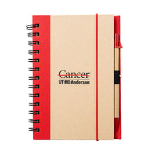 Hardcover red spiral notebook with pen featuring the full black UT MD Anderson logo in the middle.