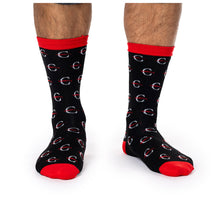 MD Anderson employee wearing black socks with red top hem, edges of toes, and sole, featuring the white strikethrough 'C' pattern.