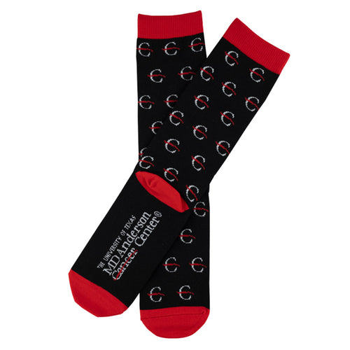 Black socks with red top hem, edges of toes, and sole, featuring the white strikethrough 'C' pattern, with the full MD Anderson logo at the bottom of the sock.