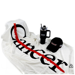 White beach towel showcasing the cancer strikethrough logo, accompanied by an MD Anderson travel mug and an MD Anderson baseball cap.