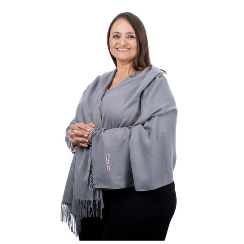 MD Anderson employee wearing a gray pashmina shawl featuring the white cancer strikethrough logo on the bottom corner.