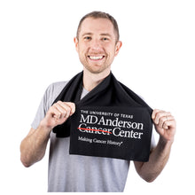 MD Anderson employee sporting a black cooling towel featuring the full white MD Anderson logo on the bottom.