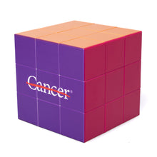 Multicolor Rubik's cube featuring the white cancer strikethrough logo.